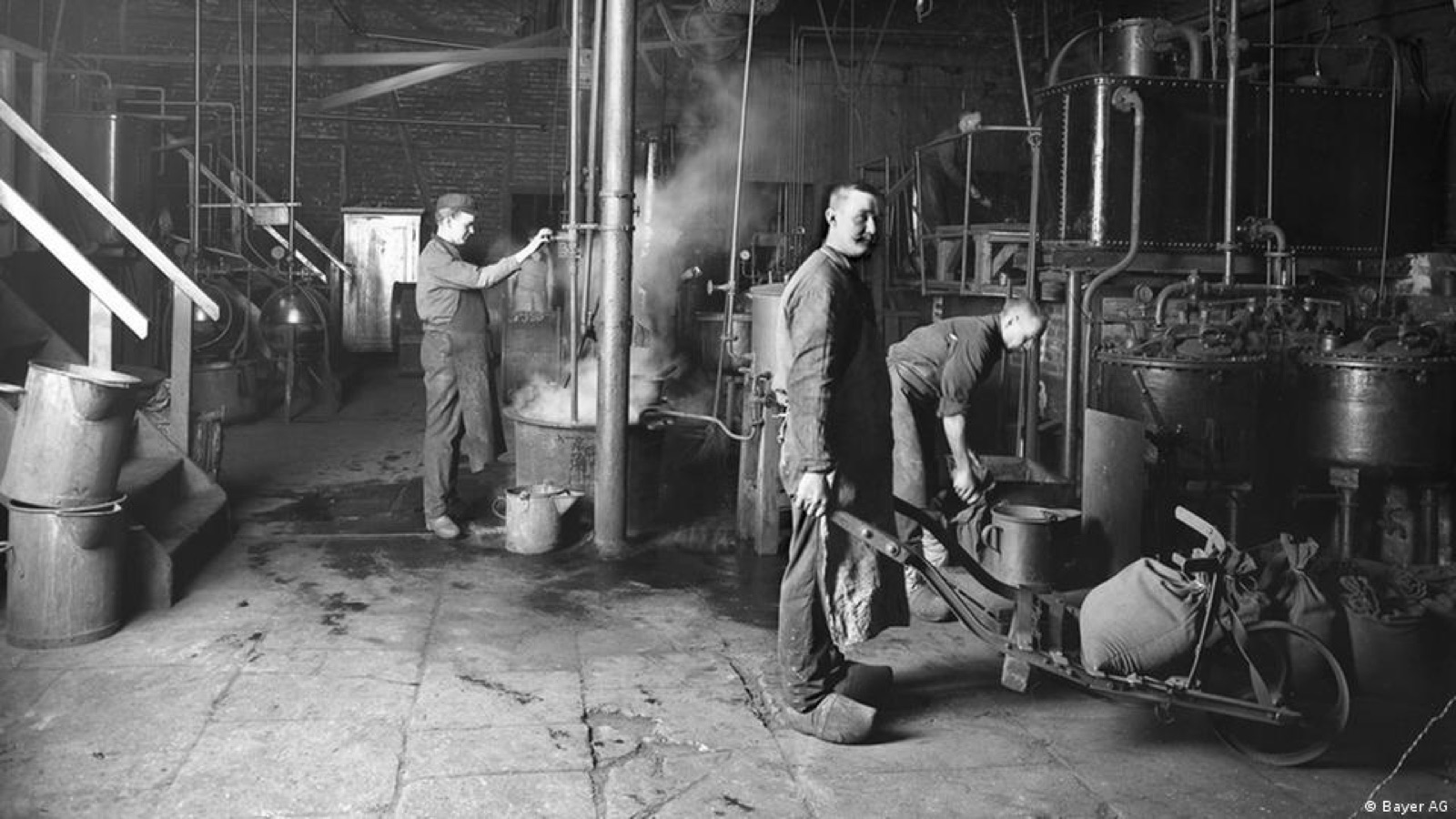 Workers at vats and stills inside an early chemical works