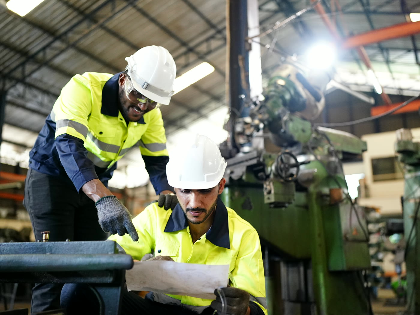 Senior engineer reviewing a spec with a colleague on the shop floor